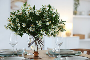 Bouquet of beautiful jasmine flowers on dining table indoors
