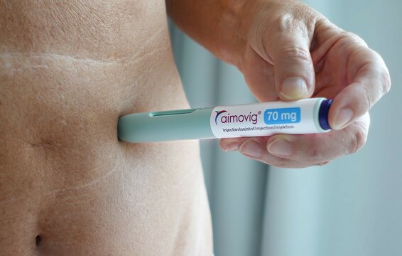 The Hague, The Netherlands - June 28, 2025: Woman injects an Aimovig, erenumab autoinjector pen for migraine in her belly, a prevention medication cgrp