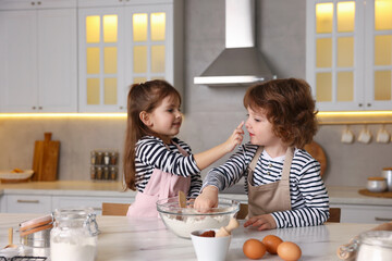 Cooking recipe. Cute children making dough for cookies at table in kitchen