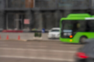 Blurred defocus background with cityscape of multi-lane road with moving vehicles such as green...