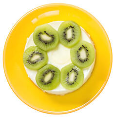 Delicious kiwi slices arranged on a white cream in a bright yellow bowl on black background