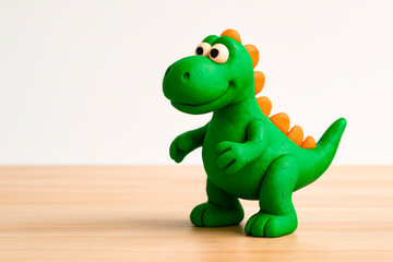Fototapeta premium A green dinosaur made of plasticine, a childhood character. Space for text.