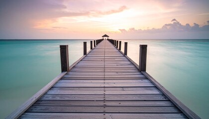 Obraz premium muelle de madera que se extiende directamente hacia el horizonte, sumergiéndose en un mar de un llamativo color turquesa.