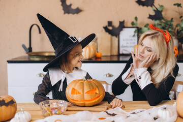 Mother and Daughter Carving Pumpkins and Having Fun for Halloween