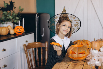 Young Girl Carving Halloween Pumpkin at Home