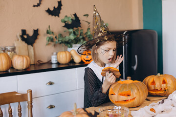 Little Girl Carving Halloween Pumpkins Wearing Witch Costume