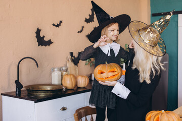 Mother and daughter preparing carved pumpkins for Halloween party