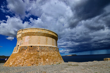 Torre defensiva troncónica en Fornells, descargan las nubes agua en alta mar todo un espectáculo...