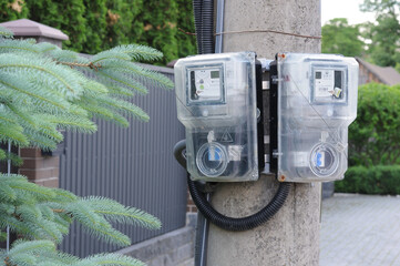 Electricity meter on the pole in front of the residential building.