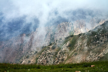 Enigmatic mountain landscape in thick fog and clouds while descending Big Chimgan. Hazy slopes...