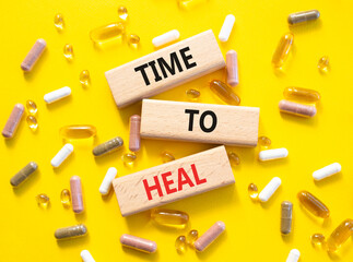 Medicine symbol. Concept words Time to Heal on wooden blocks. Beautiful yellow background with...