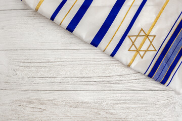 A wooden background with a Jewish religious symbol covered the tallit. The concept of Judaism and religious holidays. Empty space for text.