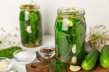 Freshly-salted homemade cucumbers in a jar on a wooden background. pickled cucumbers with dill,garlic and pepper.canned cucumbers.cucumbers and dill.Recipe of homemade preservations.fermented veggies.