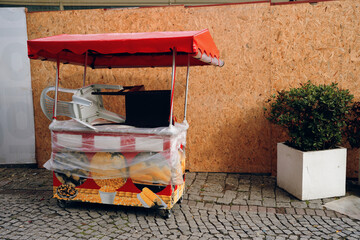 An abandoned food stall wrapped in plastic illustrates urban decay and reflects seasonal business...