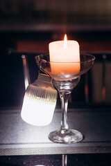 Power outage. Romance. A candle and a battery-powered lamp are on the table.