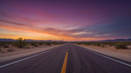 Naklejka premium Vast Desert Highway Stretches Into the Horizon Under a Colorful Twilight Sky With Layered Clouds and Distant Mountains
