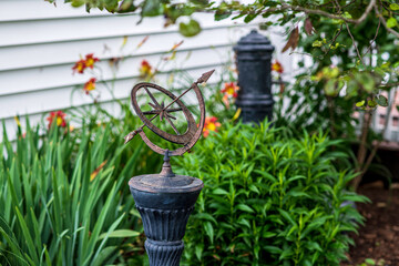 old metal sundial isolated on pedestal in garden with white background