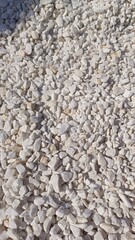 Marbled white gravel. Crushed stone texture. White background of small stones