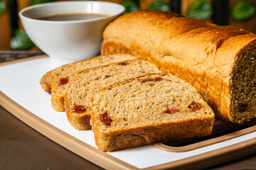 horizontal close-up photo of traditional artisan whole wheat sliced bread with guava jam next to a cup of coffee in a healthy vegetarian restaurant in Colombia