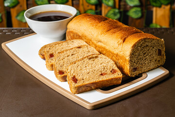 horizontal close-up photo of traditional artisan whole wheat sliced bread with guava jam next to a cup of coffee in a healthy vegetarian restaurant in Colombia