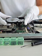Obraz premium Technician repairs laptop by replacing hard drive while wearing in a clean workspace