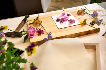 Botanical printmaking preparation – colorful fresh flowers arranged on board, DIY floral art...