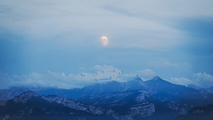 Closeup of a beautiful moon showing over the French and Swiss Alps 