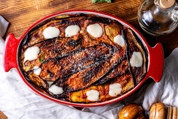 Italian eggplant Melanzane alla parmigiana close up in baking dish on the table. horizontal view from above