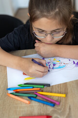 Child draws fractal patterns with crayons as part of art therapy. Creative activity for emotional...