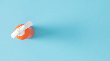 Summer vacation concept, cosmetics with SPF protection. One orange bottle of sunscreen oil with spray on blue background, banner.