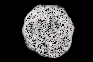 Round soap foam bubble texture on black background. Isolated circular shape of white froth....