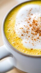 Golden Turmeric Latte with Cinnamon and Foamed Milk in White Mug