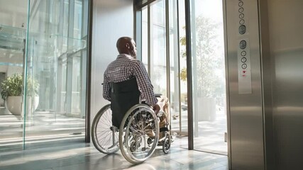 Senior black man exiting elevator in wheelchair - Powered by Adobe