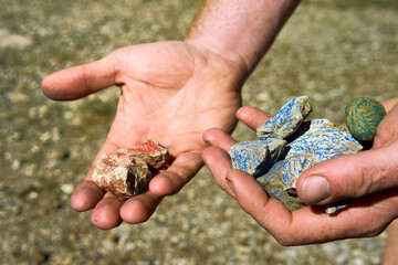Exploring colorful stones in the serene Alpine landscape under bright sunlight