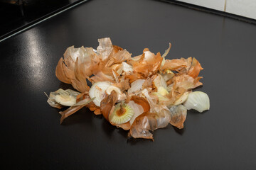 Onion peel isolated on black table.Close up of scattered dry onion peel as background.Close up view...