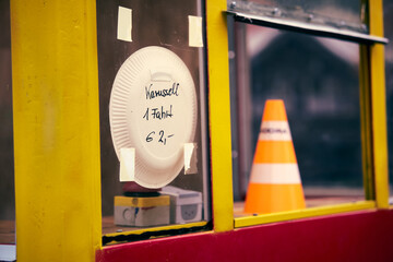 Colorful kiosk in the Alps with signs indicating the carousel ride availability and pricing during...