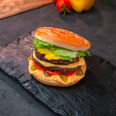 Juicy Cheeseburger with Lettuce and Tomato on Black Background