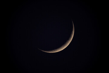 Telescope view of a thin crescent moon