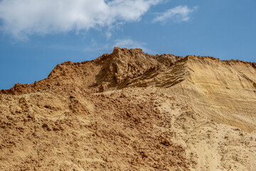 Sand against the blue sky. Sand quarry, sand mining, development