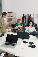young adult woman working with colleagues and friends in a modern workplace, Gen Z socializing and...