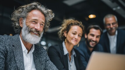 Smiling senior businessman with colleagues attending a meeting in an office during the day