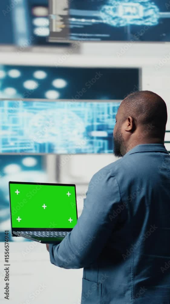 Poster vertical video black engineer works on binary code with chroma key on laptop, reflecting the mindset
