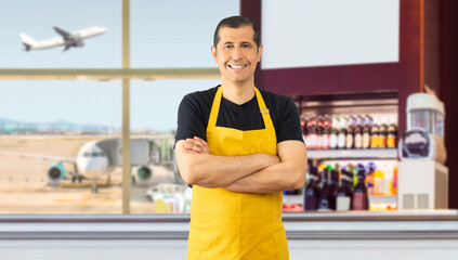 Hispanic barista with yellow apron standing in the coffee shop at an airport