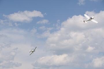 two light aircraft perform aerobatics, coming dangerously close to each other at minimum altitude