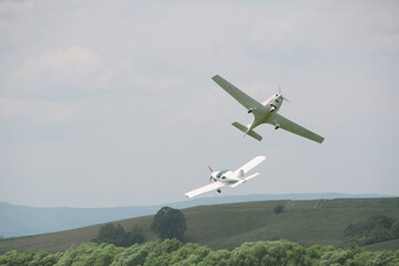 two light aircraft perform aerobatics, coming dangerously close to each other at minimum altitude