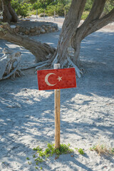 Wooden signboard with national flag of Turkey on background of Mediterranean landscape