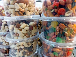 Assorted Nuts and Fruits Displayed in Clear Plastic Containers at a Market