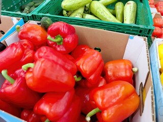 Fresh Sweet Red Peppers in Vibrant Display at a Colorful Farmers Market on a Sunny Afternoon