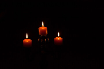 Three Lit Candles on Black Background