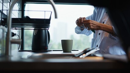 Chef adding spices to a dish in a modern and bright kitchen
